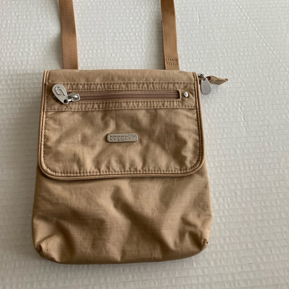 Baggalinni neutral tan Crossbody bag with adjustable strap. Lays flat.